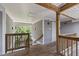 Hallway with wooden railing overlooking trees and view of entrance door at 929 Morreene Rd # C31, Durham, NC 27705