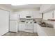 Bright kitchen features white appliances and cabinets with a view to the dining room at 929 Morreene Rd # C31, Durham, NC 27705