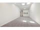 Open-concept living room with neutral carpeting, leading to other rooms and featuring bright, natural light at 929 Morreene Rd # C31, Durham, NC 27705