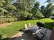 Well-maintained backyard featuring a stone patio set, dining table, and lush greenery at 9409 Collingdale Way, Raleigh, NC 27617