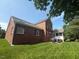 Large brick home with backyard, patio, and screened in porch, surrounded by mature trees and lawn at 9409 Collingdale Way, Raleigh, NC 27617