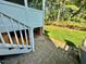 Exterior side angle view of brick house and wooden porch steps with lush lawn at 9409 Collingdale Way, Raleigh, NC 27617