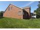 Side and backyard of beautiful brick home with well-maintained lawn and screened porch at 9409 Collingdale Way, Raleigh, NC 27617