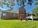 Backyard of brick house with patio and screened-in porch offer outdoor living and dining options at 9409 Collingdale Way, Raleigh, NC 27617