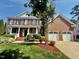 Charming two-story brick home with a well-manicured front yard and attached two-car garage at 9409 Collingdale Way, Raleigh, NC 27617