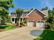 Classic brick home with a well-maintained lawn, a covered front porch, and a two-car garage at 9409 Collingdale Way, Raleigh, NC 27617