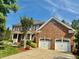 Traditional brick facade with well-maintained landscaping and a side-entry two-car garage at 9409 Collingdale Way, Raleigh, NC 27617