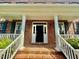 Elegant front entrance with brick steps, white columns, and a black front door at 9409 Collingdale Way, Raleigh, NC 27617