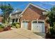 Attached two-car garage with white doors and a brick facade complements the main house at 9409 Collingdale Way, Raleigh, NC 27617