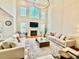 Grand living room boasts soaring ceilings, fireplace, large windows offering picturesque views, and hardwood floors at 9409 Collingdale Way, Raleigh, NC 27617