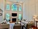 Bright living room features large windows, fireplace, and soaring ceilings with elegant chandelier at 9409 Collingdale Way, Raleigh, NC 27617