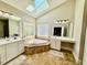 Bright bathroom with a soaking tub under a skylight, offering a spa-like experience at 9409 Collingdale Way, Raleigh, NC 27617