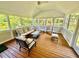 Relaxing screened porch with wood flooring and comfortable seating offers serene views of the surrounding greenery at 9409 Collingdale Way, Raleigh, NC 27617