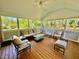 Screened porch perfect for outdoor enjoyment, featuring wood floors and cushioned seating areas at 9409 Collingdale Way, Raleigh, NC 27617