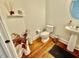 Cozy powder room with hardwood floors, white fixtures, and decor at 9409 Collingdale Way, Raleigh, NC 27617