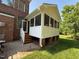 Stylish screened-in porch with outdoor patio, brickwork, and wooden steps leading to the backyard at 9409 Collingdale Way, Raleigh, NC 27617