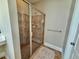 Tiled shower with glass door and chrome fixtures at 9409 Collingdale Way, Raleigh, NC 27617
