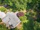Aerial view of a single-Gathering home surrounded by trees and greenery; a serene retreat at 106 Wolfs Trl, Chapel Hill, NC 27516