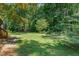 Large backyard featuring lush greenery and mature trees at 106 Wolfs Trl, Chapel Hill, NC 27516