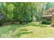 Lush backyard with trees, lawn and partial view of home at 106 Wolfs Trl, Chapel Hill, NC 27516