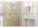 Elegant bathroom featuring a tiled shower, pedestal sink and wainscoting at 106 Wolfs Trl, Chapel Hill, NC 27516