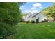 A lovely backyard view of home's exterior, featuring landscaping, green grass, and space for recreation and enjoyment at 110 Benedum Pl, Cary, NC 27518