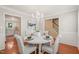 Elegant dining room featuring a round table, chandelier, and views into kitchen and staircase at 110 Benedum Pl, Cary, NC 27518