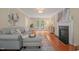 Cozy living room with hardwood floors, a fireplace, and French doors leading to the backyard at 110 Benedum Pl, Cary, NC 27518