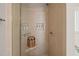 Modern shower with tile surround, built-in shelving, and glass door at 110 Benedum Pl, Cary, NC 27518