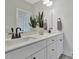 Bright bathroom featuring double sinks, sleek black faucets, and a large mirror reflecting a plant in a pot at 1100 Balsawood Dr # 5, Durham, NC 27705