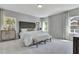 Spacious main bedroom featuring a tufted headboard, soft carpet, bench, and natural lighting at 1100 Balsawood Dr # 5, Durham, NC 27705