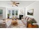 Bright living room features stylish furniture, fireplace, hardwood floors, and natural light from large windows at 120 Martingale Dr, Holly Springs, NC 27540
