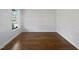 A room with hardwood floors, a large window, and white trim at 120 Martingale Dr, Holly Springs, NC 27540