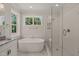 Bright bathroom featuring a soaking tub and glass-enclosed shower with marble floors at 120 Pilot Ridge Rd, Zebulon, NC 27597