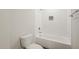 Bathroom featuring a toilet, bathtub, shower, and a towel rack, all set against white-tiled walls at 120 Pilot Ridge Rd, Zebulon, NC 27597