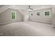 Bright bedroom showcasing plush carpeting, abundant natural light from several windows, and a sleek ceiling fan at 120 Pilot Ridge Rd, Zebulon, NC 27597