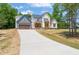 New construction two-story home with stone accents, gray garage, and a long concrete driveway at 120 Pilot Ridge Rd, Zebulon, NC 27597