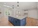 Open concept kitchen with a large center island, granite countertops, and modern pendant lighting at 120 Pilot Ridge Rd, Zebulon, NC 27597