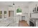 Gourmet kitchen with white cabinets, granite counters, modern appliances, and a view of the backyard at 120 Pilot Ridge Rd, Zebulon, NC 27597