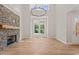 Bright living room with stone fireplace, wood mantel, and large windows at 120 Pilot Ridge Rd, Zebulon, NC 27597