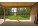 Covered back porch with tiled floor and a view of a wooded backyard at 1212 Perry Bluff Dr, Wake Forest, NC 27587