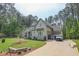 The exterior of the house shows the driveway and the lush tree coverage along the exterior of the lot at 1212 Perry Bluff Dr, Wake Forest, NC 27587