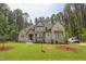 A traditionally styled home features a stone entryway and a well-manicured lawn surrounded by mature trees at 1212 Perry Bluff Dr, Wake Forest, NC 27587