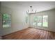 Bright living room featuring hardwood floors, large windows, and modern chandelier at 1212 Perry Bluff Dr, Wake Forest, NC 27587