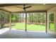 Covered outdoor patio with ceiling fan overlooking expansive green lawn and wooded area at 1212 Perry Bluff Dr, Wake Forest, NC 27587