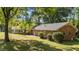 Brick ranch house with a well-maintained lawn and mature trees on a sunny day at 129 Castle Dr, Smithfield, NC 27577