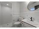 All-white bathroom featuring a shower and updated sink with a black faucet and round mirror at 129 Castle Dr, Smithfield, NC 27577