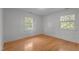 Well-lit bedroom with hardwood floors and ample natural light from two windows at 129 Castle Dr, Smithfield, NC 27577
