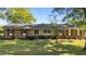 Charming single-story brick home featuring a lush front yard and a welcoming red double-door entrance at 129 Castle Dr, Smithfield, NC 27577