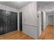 Inviting hallway with hardwood floors, striped wallpaper, and stylish black doors at 129 Castle Dr, Smithfield, NC 27577